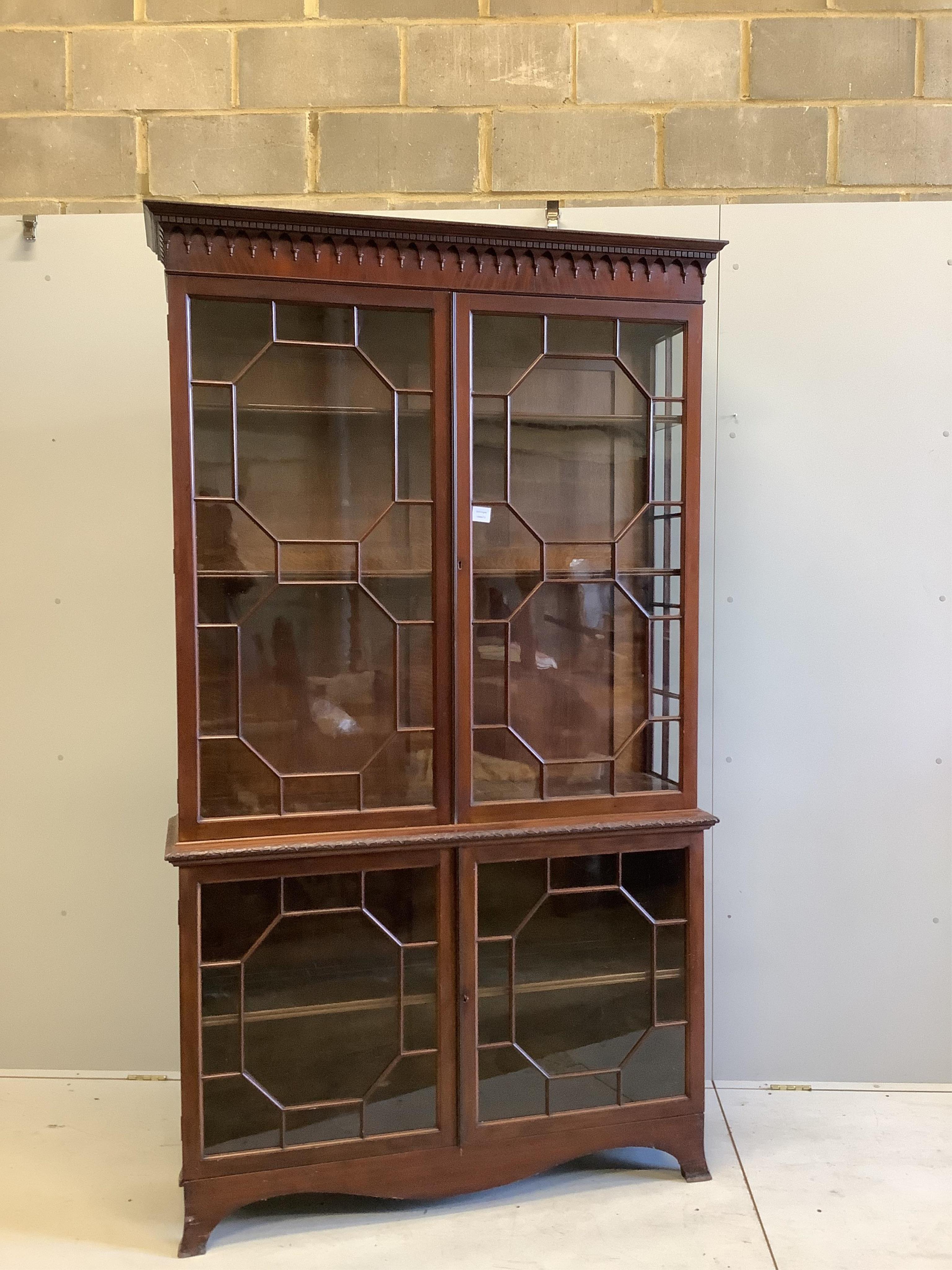 A George III style mahogany bookcase, enclosed by two pairs of astragal glazed doors, width 122cm, depth 35cm, height 214cm. Condition - fair to good